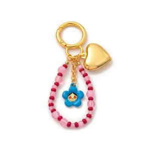 Vista macro del ciondolo a cuore e del fiore blu su un accessorio per borsa con perle
