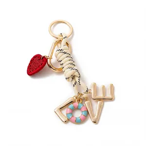 Close-up of stylish DIY bag charm with rope knot, strawberry and LOVE charms