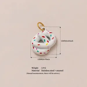 Dettaglio del ciondolo a forma di pretzel in smalto bianco con granelli colorati e oro