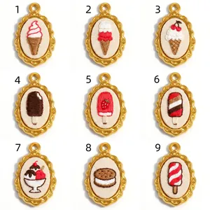 Detailed view of nine unique embroidered dessert pendants in golden stainless steel frames.