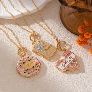 Detailopname van drie goudkleurige MOM-hangers met verfijnde florale emaille-ontwerpen