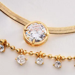 Close-up detail of a layered gold snake bone chain necklace with sparkling cubic zirconia