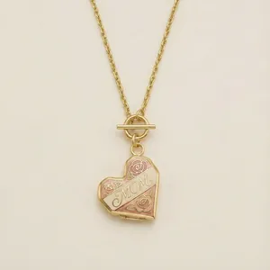 Gouden hart medaillon ketting met MOM gravure en roze emaille roos detail, close-up