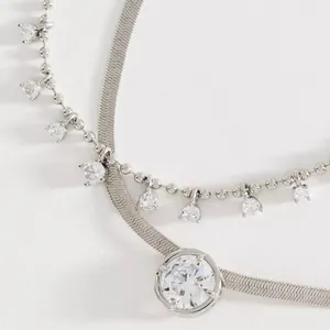Close-up of elegant silver-tone snake chain necklace with sparkling cubic zirconia charms