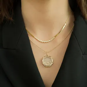 Vue détaillée d'un collier avec pendentif médaillon en or et inscription LOVE porté