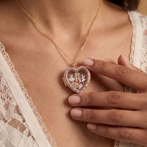 Primo piano di un medaglione a cuore dorato con ciondoli a tema balletto su pizzo