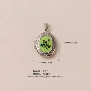 Close-up detail of silver oval locket with green floral inlay and 20mm height measurement