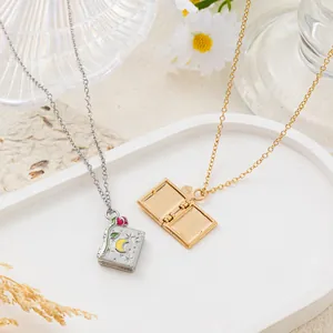 Vista macro de collares de relicario de libro vintage con grabados de rosa luna y estrellas