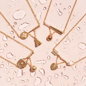 Detailed view of gold sports-themed necklaces featuring badminton, baseball, and heart charms.