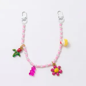 Detailansicht eines bunten Perlen-Taschenanhängers mit Blumen- und Bärenanhängern.