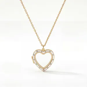 Dettaglio di una collana a medaglione a cuore dorato con smalto bianco e pietre