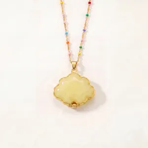 Gros plan du collier médaillon nuage plaqué or avec détails de perles arc-en-ciel