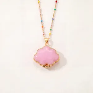 Vue détaillée d'un collier médaillon nuage rose avec perles colorées sur chaîne dorée