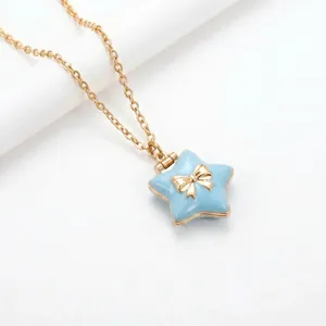 Detail macro view of a light blue star-shaped locket necklace featuring a gold bow.
