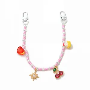 Detailansicht eines rosa-weißen Perlen-Taschenanhängers mit Kirsch-Anhänger.