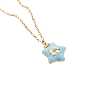 Close-up of a gold-plated star locket necklace with a blue enamel finish and bow.