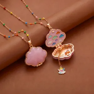 Gros plan détaillé d'un collier médaillon nuage doré avec des nuages en émail coloré