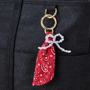 Nahaufnahme eines roten Paisley-Schlüsselanhängers mit Perlbogen auf einer Tasche