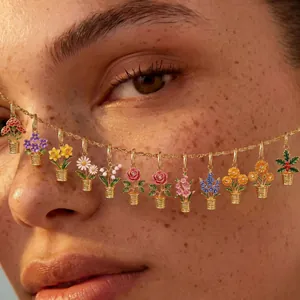 Macro detail of twelve vibrant enamel flower charms hanging from a delicate gold chain necklace