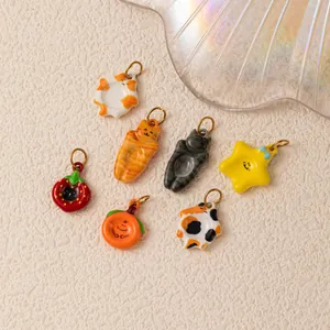 Detail view of assorted cute cartoon cat and fruit charms for DIY jewelry making
