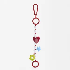 Vibrant beaded bag charm featuring heart star and flower pendants on sturdy red rings