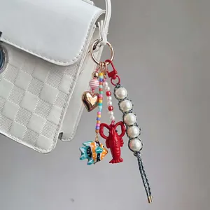 Portachiavi di perline colorate con ciondoli a forma di cuore e aragosta sulla borsa