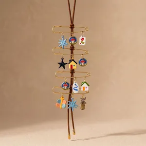 Close-up of DIY stainless steel jewelry charms with 18K gold plated safety pins and motifs