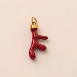 Macro del ciondolo a forma di ramo rosso placcato in oro 18 carats per gioielli