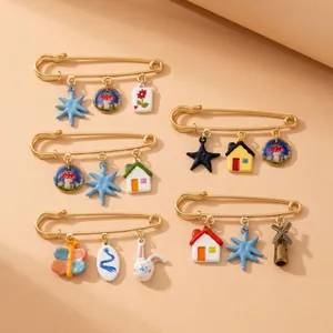 Detail view of 18K gold plated stainless steel safety pins with colorful charms.