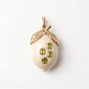 Détail du pendentif en forme de citron avec feuilles d'or et pierres vertes