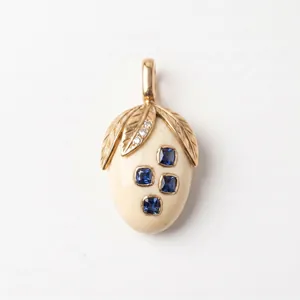Vue macro détaillée d'un pendentif gland avec feuilles d'or et pierres bleues carrées