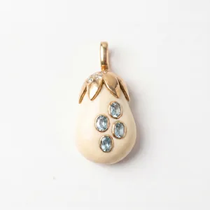 Détail macro d'un élégant pendentif aubergine doré incrusté de pierres précieuses bleues