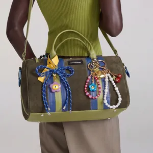 Set di ciondoli vintage per borsa con cuore e fiori su una borsa di camoscio verde