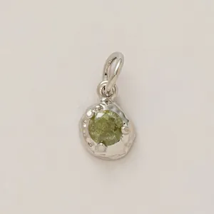 Handcrafted textured silver charm with a vibrant round green gemstone for DIY jewelry