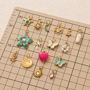 Sammlung verschiedener 18K vergoldeter Edelstahlanhänger auf einem Gitterbrett für DIY Schmuck.