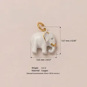 Vista detallada de un colgante de elefante de esmalte blanco con detalles dorados.