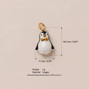 Detalle macro de un colgante de pingüino pintado a mano con medidas e información de material