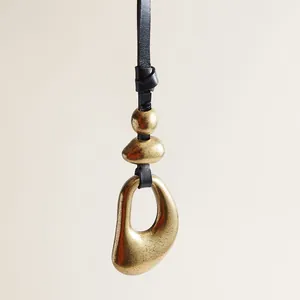 Macro view of vintage leather strap with antique bronze irregular metal ring pendant