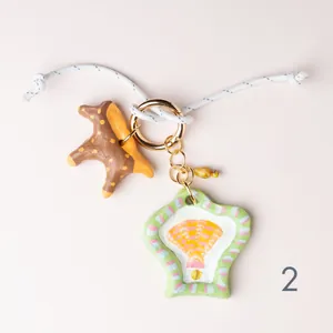 Detail showing hand-painted ceramic-style charms with a seashell and star motif.