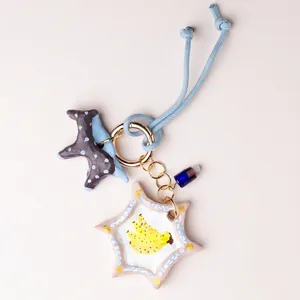 Detail of handmade star bag charm with hand-painted banana illustration
