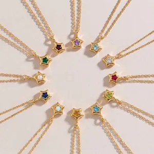 Vue de dessus de douze pendentifs étoile avec pierres de naissance disposés en cercle.