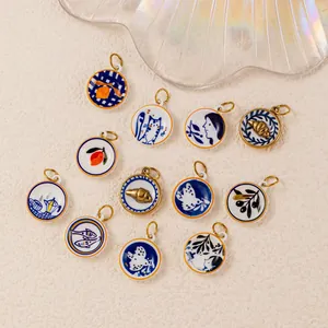 Detail of various stainless steel DIY charms with blue artistic patterns and 18K gold plating