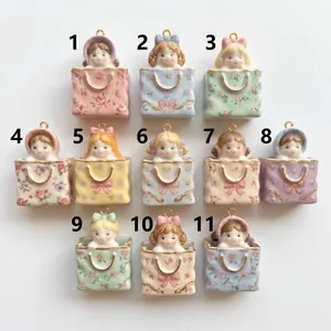 Lot de onze breloques poupées en céramique avec motifs de sacs à fleurs