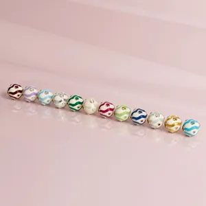 Detailed macro view of colorful birthstone charms with wavy enamel and inlaid crystals