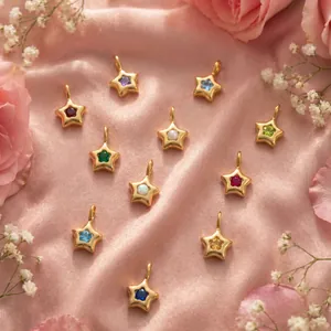 Vue détaillée de plusieurs pendentifs étoiles pierre de naissance sur soie rose élégante