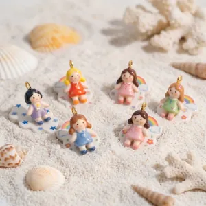 Dettaglio di ciondoli colorati a forma di bambina per collane fai-da-te su sabbia