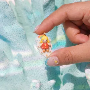 Dettaglio macro di un ciondolo a forma di ragazza colorata con arcobaleno e nuvole
