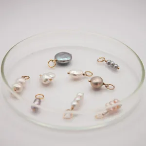 Vista detallada de dijes de perlas barrocas en varios colores para la creación de joyas DIY