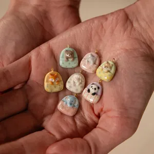 Macro view of cute handcrafted ceramic animal pendants sleeping in cozy little beds.