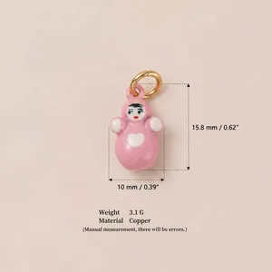 Detail showing a pink doll pendant charm with copper material and size measurements